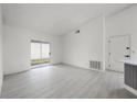 Open concept living room with sliding glass doors and light wood-look flooring at 2978 Stillwater Dr, Kissimmee, FL 34743