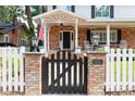 Inviting front gate with brick columns, lantern lighting, and an American flag on the charming front porch at 3 W Yale St, Orlando, FL 32804
