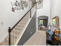 Elegant staircase with a combination of carpeted treads and tile flooring at 3055 Ashland N Ln, Kissimmee, FL 34741