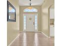 Bright foyer with beige walls, tile flooring and large mirror at 33243 Kaylee Way, Leesburg, FL 34788