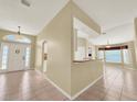 Open-concept home with tile flooring connecting the foyer, kitchen, and living areas at 33243 Kaylee Way, Leesburg, FL 34788