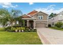 Charming two-story home featuring a well-manicured lawn, lush landscaping, and a welcoming front porch at 3404 Shallow Cove Ln, Clermont, FL 34711