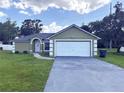 Front exterior of home featuring a garage, manicured lawn, and blue sky at 431 Eagle Dr, Poinciana, FL 34759