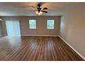 Bright living room with modern ceiling fan, wood-look floors, and slider door to backyard at 4792 Summerfield Cir, Winter Haven, FL 33881
