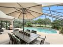 Outdoor dining set and grill next to a screen enclosed pool and patio area at 518 Stephanie Ct, Lake Mary, FL 32746