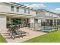 A covered patio with outdoor furniture overlooks a screened-in pool and grassy lawn at 7456 Marker Ave, Kissimmee, FL 34747
