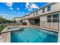 A clear, sparkling swimming pool and spa are surrounded by a safety fence at 7456 Marker Ave, Kissimmee, FL 34747