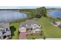 An aerial view of this waterfront home showcasing its brick driveway, lush landscaping, and proximity to the lake at 10117 Atwater Bay Dr, Winter Garden, FL 34787