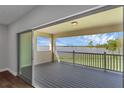 Relax on the spacious balcony with a view of the tranquil lake, complete with sliding glass doors and gray deck at 10117 Atwater Bay Dr, Winter Garden, FL 34787