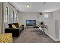 Comfortable living room with a gray sofa, yellow accents, and a dedicated workspace area at 11158 Hollow Bay Dr, Winter Garden, FL 34787