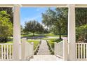 Scenic view from the covered front porch showcasing the lush greenery and serene pond at 11333 Camden Park Dr, Windermere, FL 34786