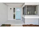 Close-up of the front door with sidelight and modern hardware, complemented by a small garden bed at 116 Morning Glory Dr, Lake Mary, FL 32746