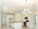 Charming kitchen with white cabinets, a kitchen island, and stainless steel appliances at 1328 Lombardi Ct, Poinciana, FL 34759