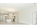 Open concept living and kitchen area boasts a chandelier and lots of natural light at 1328 Lombardi Ct, Poinciana, FL 34759