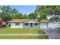 Lovely single-story home with a lush green lawn and a welcoming front porch highlighted with bright blue trim at 1328 S Oxalis Ave, Orlando, FL 32807