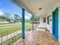 Inviting covered porch detailed with decorative railings and blue pillars, enhancing curb appeal and outdoor living at 1328 S Oxalis Ave, Orlando, FL 32807