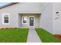 Close-up of a home's front entrance with a well-manicured lawn and modern lighting at 16057 Sw 17Th Ave, Ocala, FL 34473