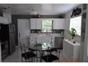 Bright kitchen with white cabinets, a window view, stainless steel appliances, and a cozy dining area at 233 N Hudson St, Orlando, FL 32835