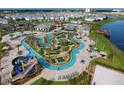 Aerial view of resort-style community amenities with lazy river, water slides, mini golf, sand volleyball, and surrounding residences at 2850 Bookmark Dr, Kissimmee, FL 34746