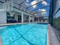 Inviting screened-in pool area with basketball hoop, in-ground pool, and comfortable outdoor seating and dining at 2850 Bookmark Dr, Kissimmee, FL 34746