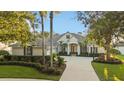 Inviting home with beautiful landscaping, swaying palm trees, and a circular driveway creating an attractive exterior at 3267 Regal Crest Dr, Longwood, FL 32779