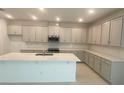 Well-equipped kitchen with modern appliances and ample counter space at 335 Ridgemark Ave, Groveland, FL 34736