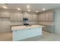 Modern kitchen with stainless steel appliances and a spacious center island at 335 Ridgemark Ave, Groveland, FL 34736