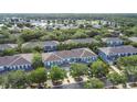 Aerial view of the community showcasing the townhomes, mature trees, and a nearby lake at 3559 Victoria Pines Dr # 280, Orlando, FL 32829