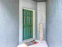Inviting green front door with a welcome mat and sign, creating a warm entrance at 3559 Victoria Pines Dr # 280, Orlando, FL 32829