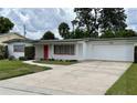 Welcoming single-story home featuring a well-maintained lawn, driveway and charming red front door at 3716 Neptune Dr, Orlando, FL 32804