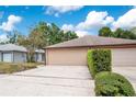 Beige one-story home featuring an attached two-car garage, and partial landscaping at 378 Cedarbrook Ln, Altamonte Springs, FL 32714