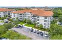 Condo building featuring a red tile roof, balconies, and lush landscaping at 4001 Breakview Dr # D409, Orlando, FL 32819
