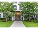 Close-up of the entrance to the condo building, with flowering trees and manicured lawn at 4001 Breakview Dr # D409, Orlando, FL 32819