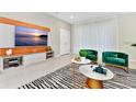 Contemporary living room features plush chairs, zebra-striped rug, and a large TV with a light wood display at 4021 Lana Ave, Davenport, FL 33897
