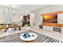 Bright open-concept living room with modern furnishings, dining area, and a TV with a light wood display at 4021 Lana Ave, Davenport, FL 33897