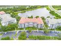 Aerial view of resort condos with a red tile roof, surrounded by trees and overlooking a large lake at 4114 Breakview Dr # 110, Orlando, FL 32819