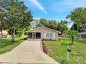 Beautiful single-story home with a screened porch, concrete driveway, and well-kept landscaping at 458 Spring Ln, Ocala, FL 34472