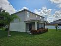 Exterior of home, with a screened patio, beige siding, and flower bed at 4901 Stone Acres Cir, St Cloud, FL 34771