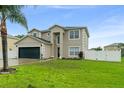 Charming two-story home with a well-maintained lawn and a two-car garage at 605 Elbridge Dr, Kissimmee, FL 34758