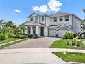 Charming two-story home with a welcoming front porch, two-car garage, and manicured lawn at 6905 Cucamelon Ct, Windermere, FL 34786