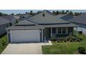 Inviting single-story home with two-car garage, landscaped lawn, and sidewalk at 744 Barron Pl, The Villages, FL 32163