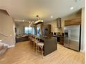 The kitchen features an island with barstool seating, stainless steel appliances, and hardwood floors at 7528 Brooklyn Dr, Kissimmee, FL 34747