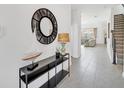 Inviting foyer with console table, a stylish round mirror and views into the open living space at 9175 Sommerset Hills Dr, Davenport, FL 33896