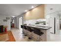 Bright kitchen features a breakfast bar with seating, white appliances, and tiled floors at 1105 Apple Ter, Leesburg, FL 34748