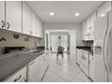 Well-lit kitchen features white appliances, ample cabinet space, and an adjacent dining area at 1105 Apple Ter, Leesburg, FL 34748