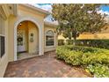 Inviting front entrance with a charming brick walkway and manicured landscaping at 11834 Gennaro Ln, Orlando, FL 32827