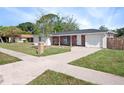 Street view of a single-story home with a brick facade, an attached garage, and a well-kept lawn at 1432 Findlay St, Deltona, FL 32725