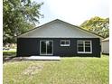 Rear view of the home showcases a sliding glass door, windows and a cozy patio space, surrounded by green grass at 1502 W 16 Th Street, Sanford, FL 32771