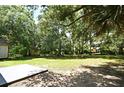 Expansive backyard offers a serene outdoor space with lush greenery and a concrete patio area at 1502 W 16 Th Street, Sanford, FL 32771