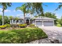 Charming single-story home with a manicured lawn, mature landscaping, and a three-car garage at 1640 Wild Indigo Ter, Oviedo, FL 32766